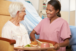 caregiver giving meals to patient